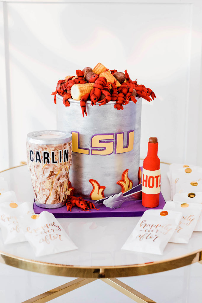 groom's cake with fondant icing featuring crawfish in an LSU pot, hot sauce, and a camou yeti